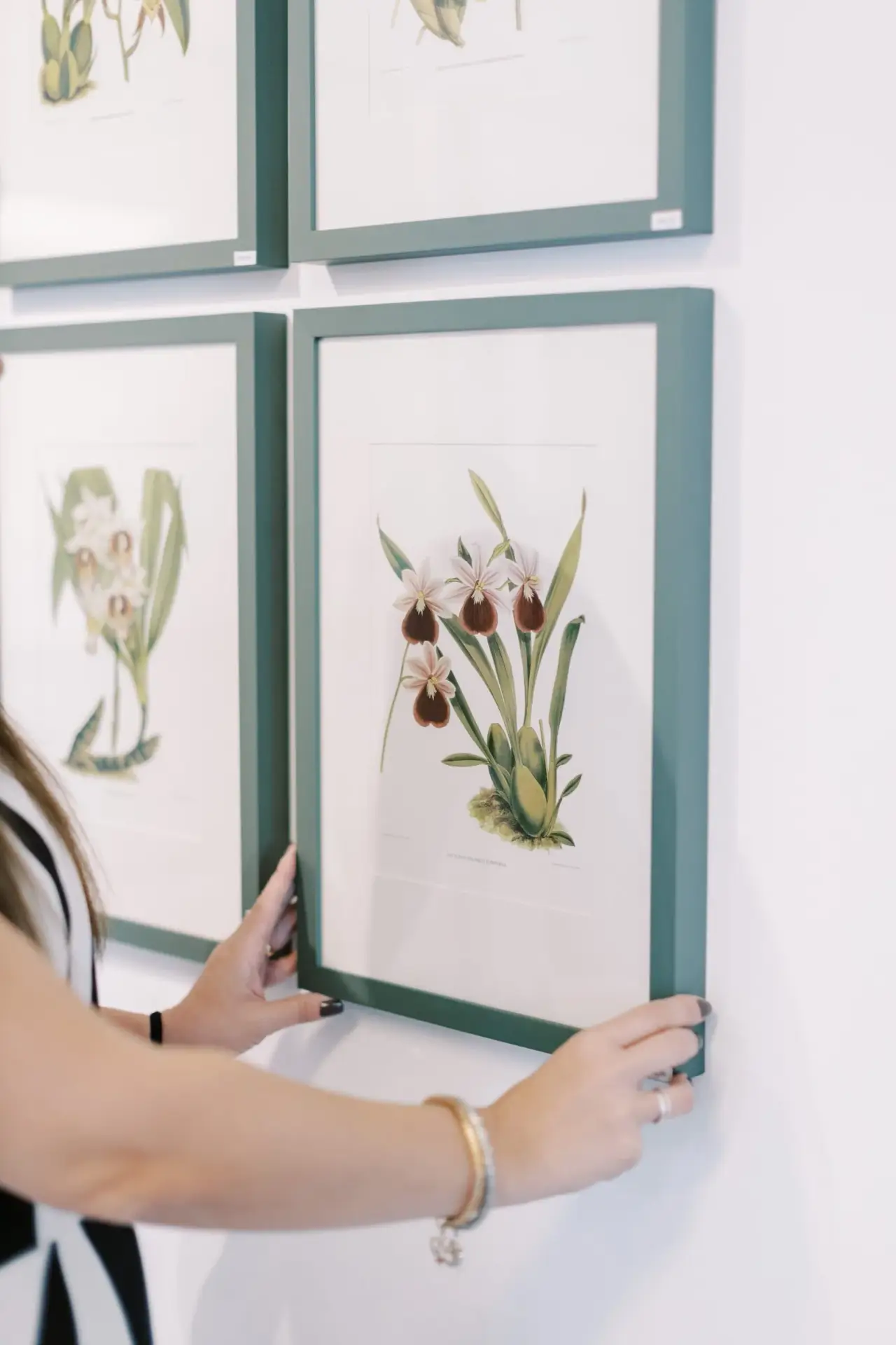Especialista da Moldura Minuto posicionando um quadro emoldurado na parede